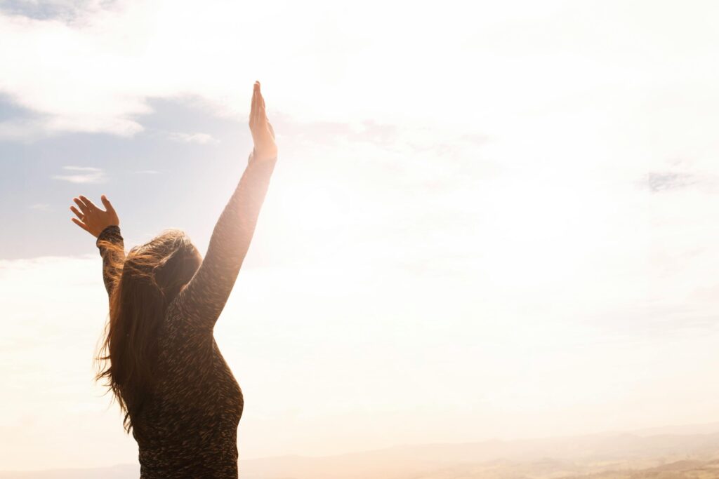 woman with her hands raised as if celebrating being free
