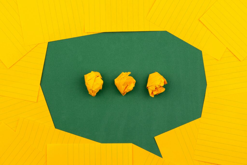 The meaning of emotions...A green speech bubble surrounded by yellow note cards with three crumpled paper dots inside, representing emotional messages and emotional awareness.